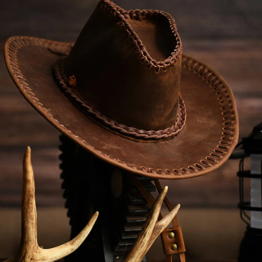 Men's hand-stitched cowhide western cowboy hat in a warm rustic setting
