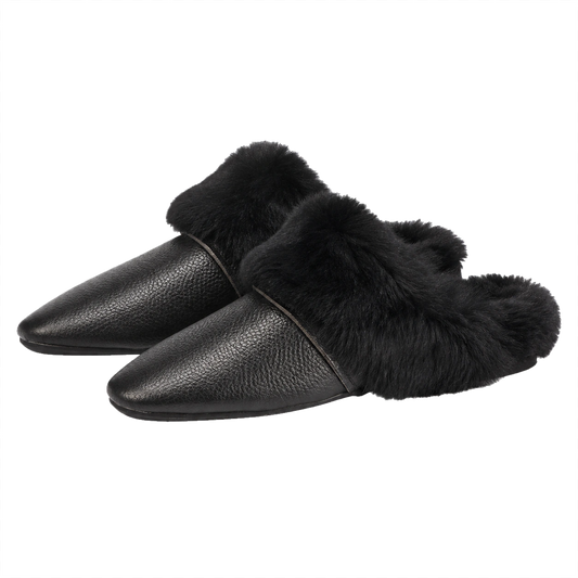 Black genuine cowhide and rabbit fur mule slippers pair on a transparent background