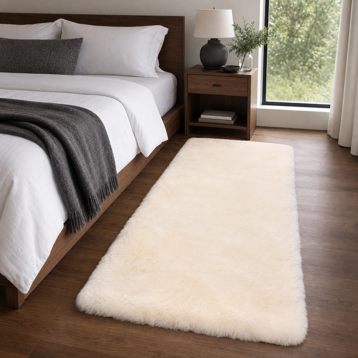 Capricornus Living Off-White genuine short-pile sheepskin runner styled beside a walnut bed