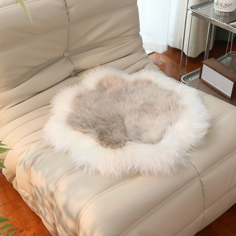 Capricornus Living Ivory Border and Taupe Center sheepskin flower chair pad on a chair