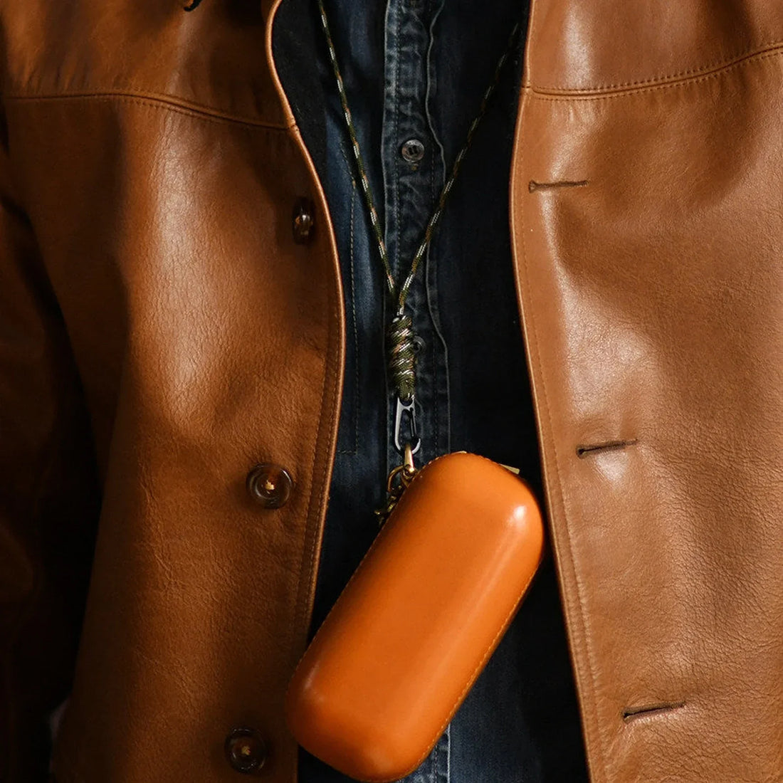 Tan vegetable-tanned leather eyeglass case worn with a clip