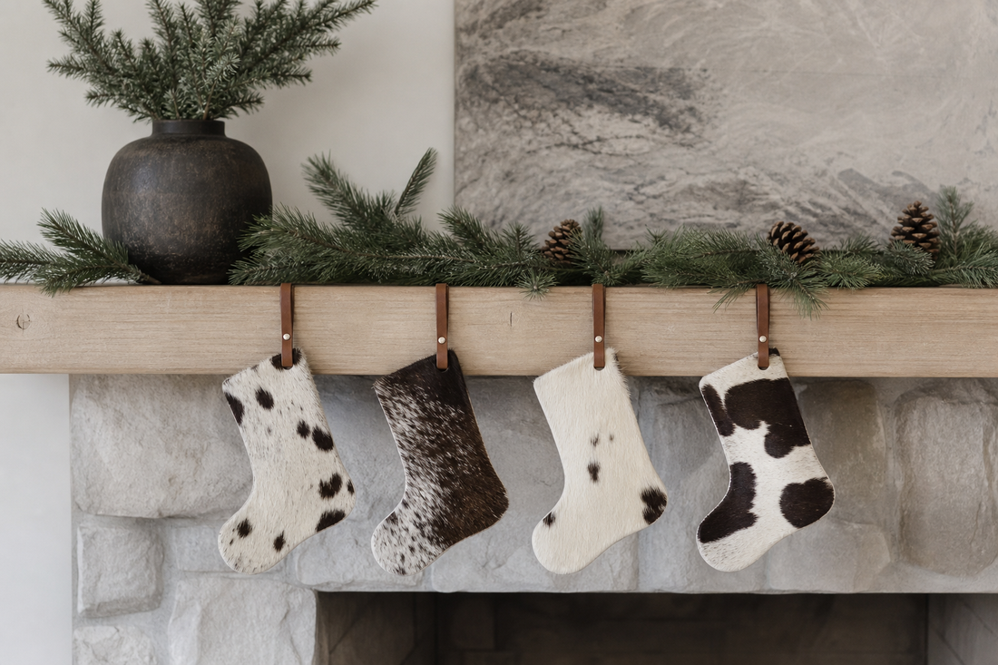 Four cowhide stocking holiday ornament silhouettes spaced on a cool dry mantel away from flame