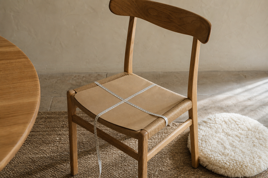 Usable width and depth being measured on a wooden dining chair before choosing a natural chair pad