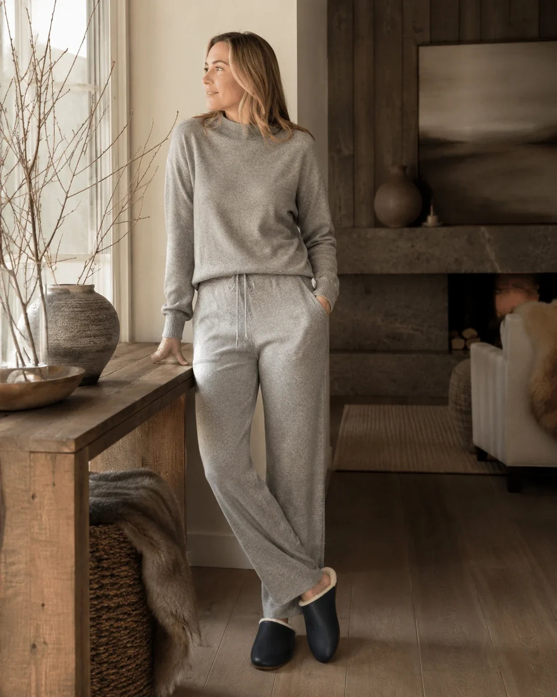 Capricornus Living Black lambskin plush-lined slippers worn in a quiet home interior