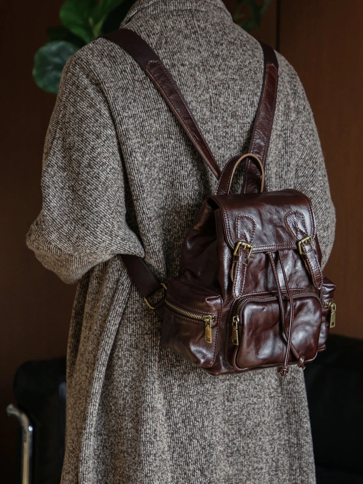 Coffee brown vegetable-tanned leather backpack worn on the shoulder