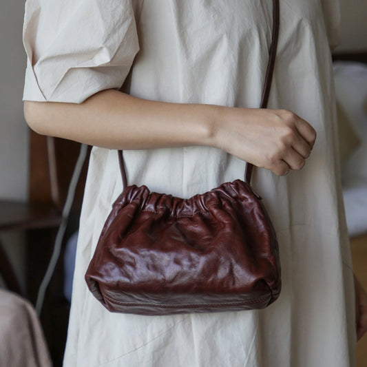 Dark brown vegetable-tanned leather ruched cloud shoulder bag worn in hand