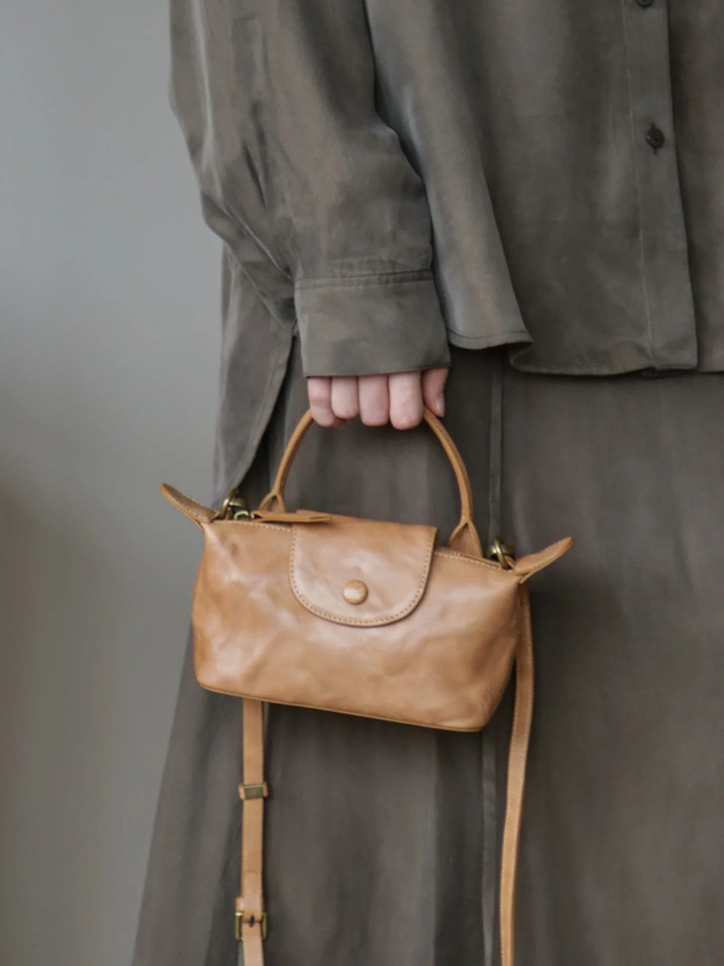 Chestnut vegetable-tanned leather mini bag carried by the top handle