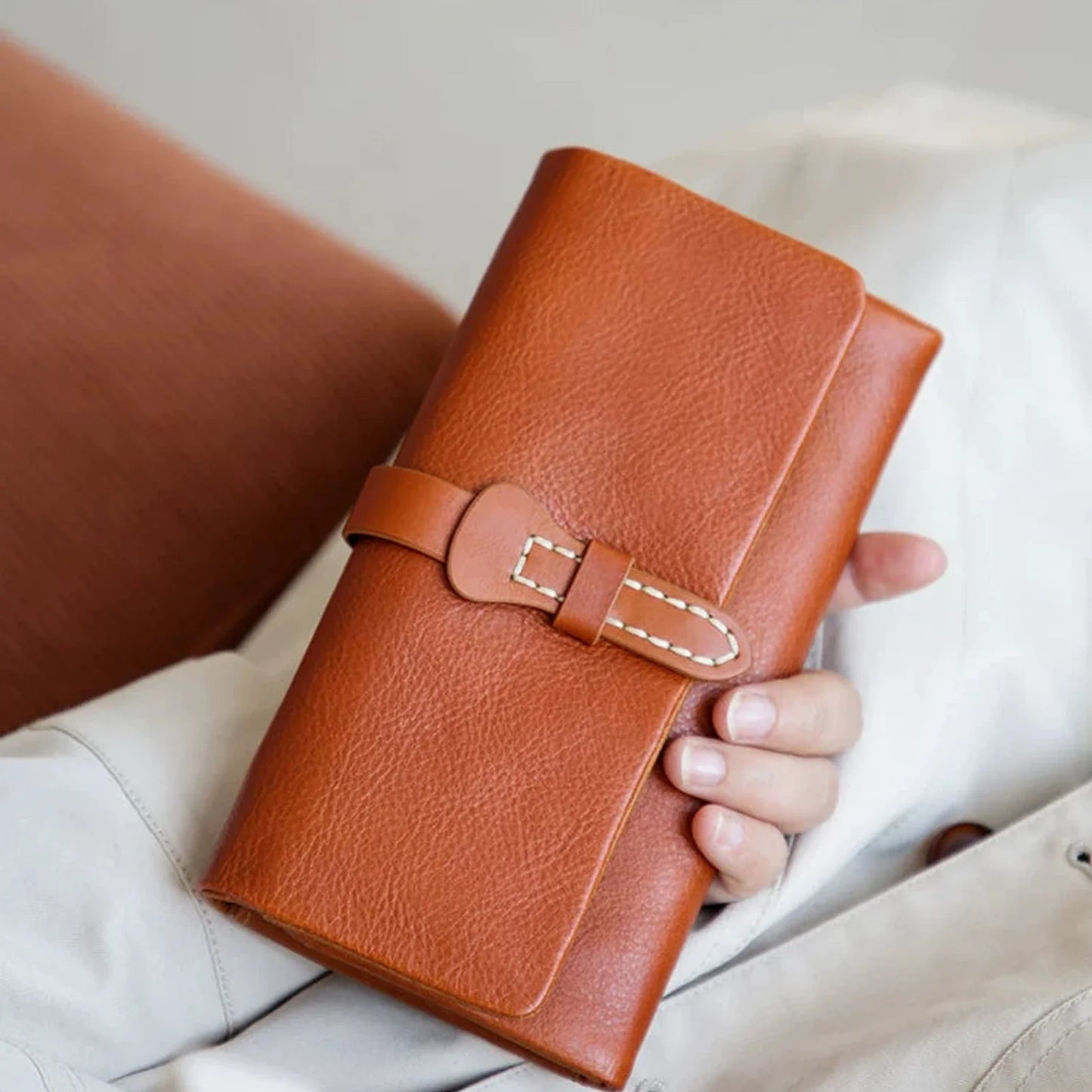 Cognac vegetable-tanned top-grain leather long wallet held in hand