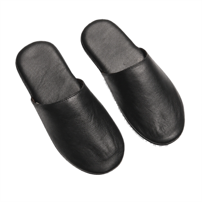Black lambskin foldable travel slippers pair on a transparent background