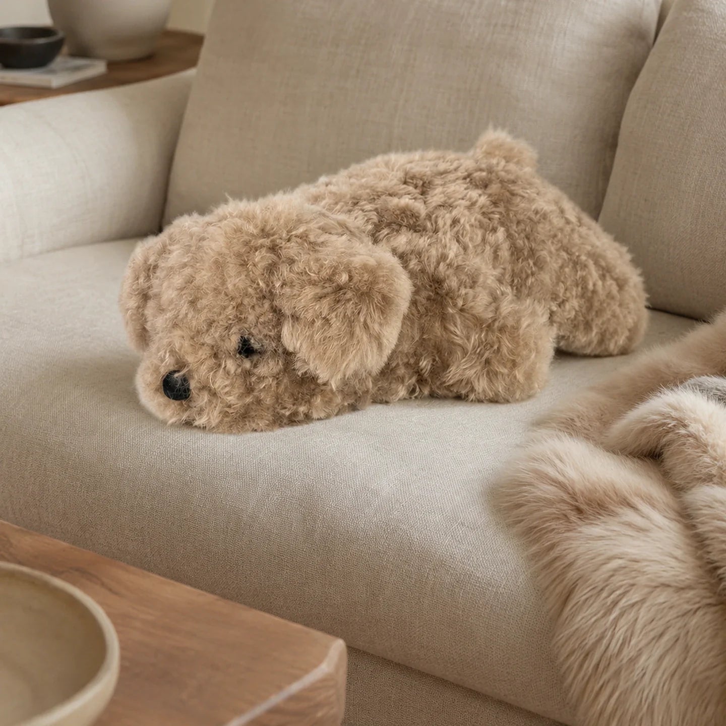 Light cocoa lambswool poodle pillow on a neutral sofa