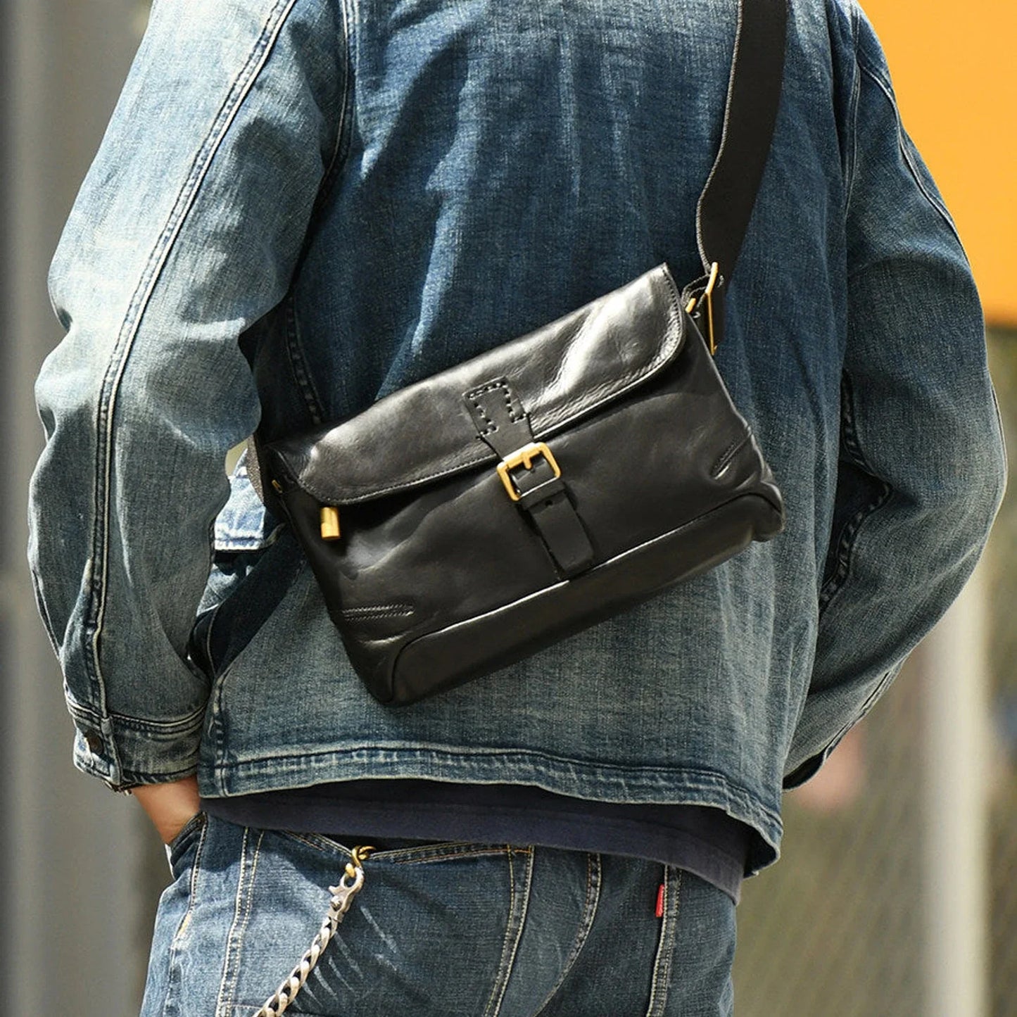 Black vegetable-tanned cowhide crossbody messenger bag worn with denim