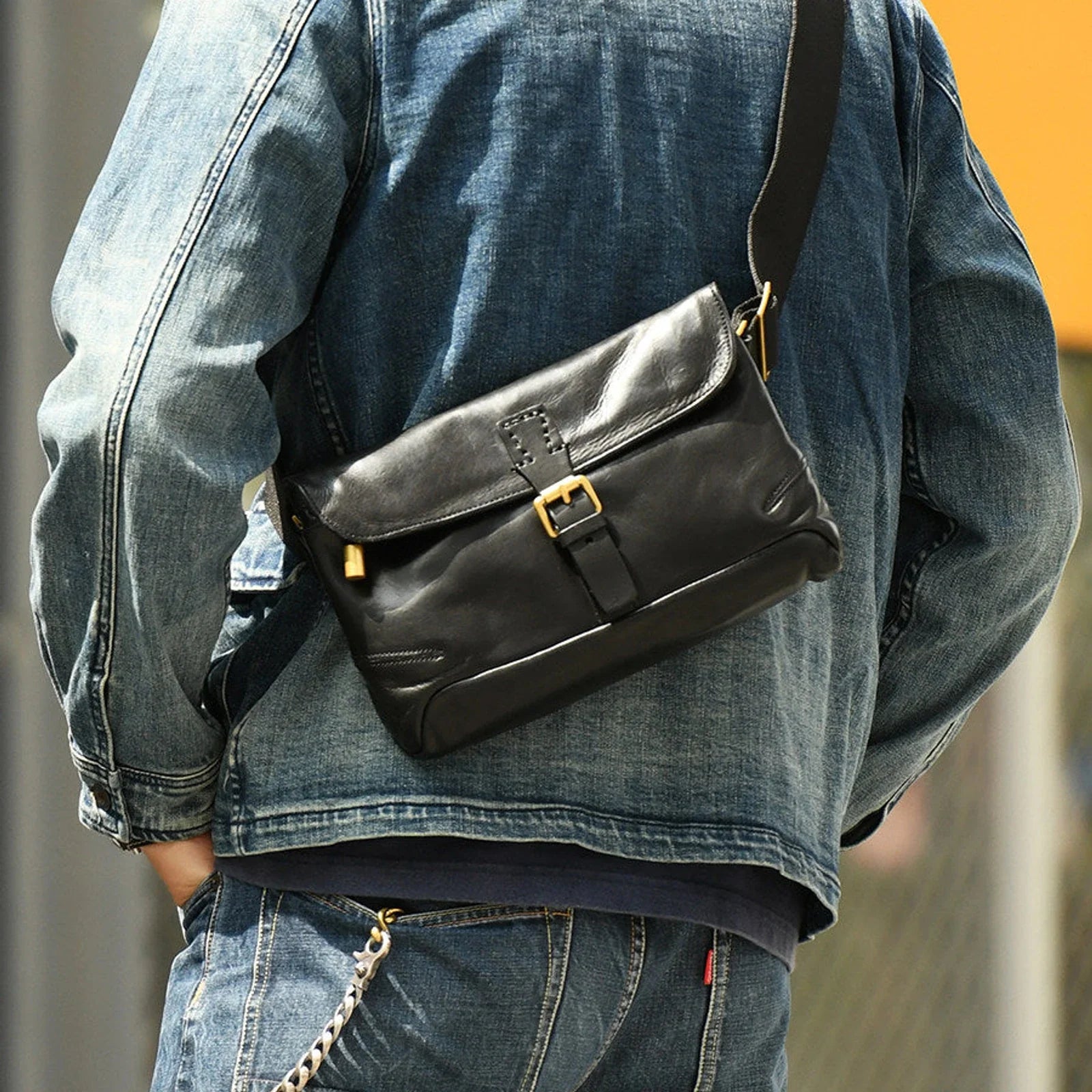 Black vegetable-tanned cowhide crossbody messenger bag worn with denim