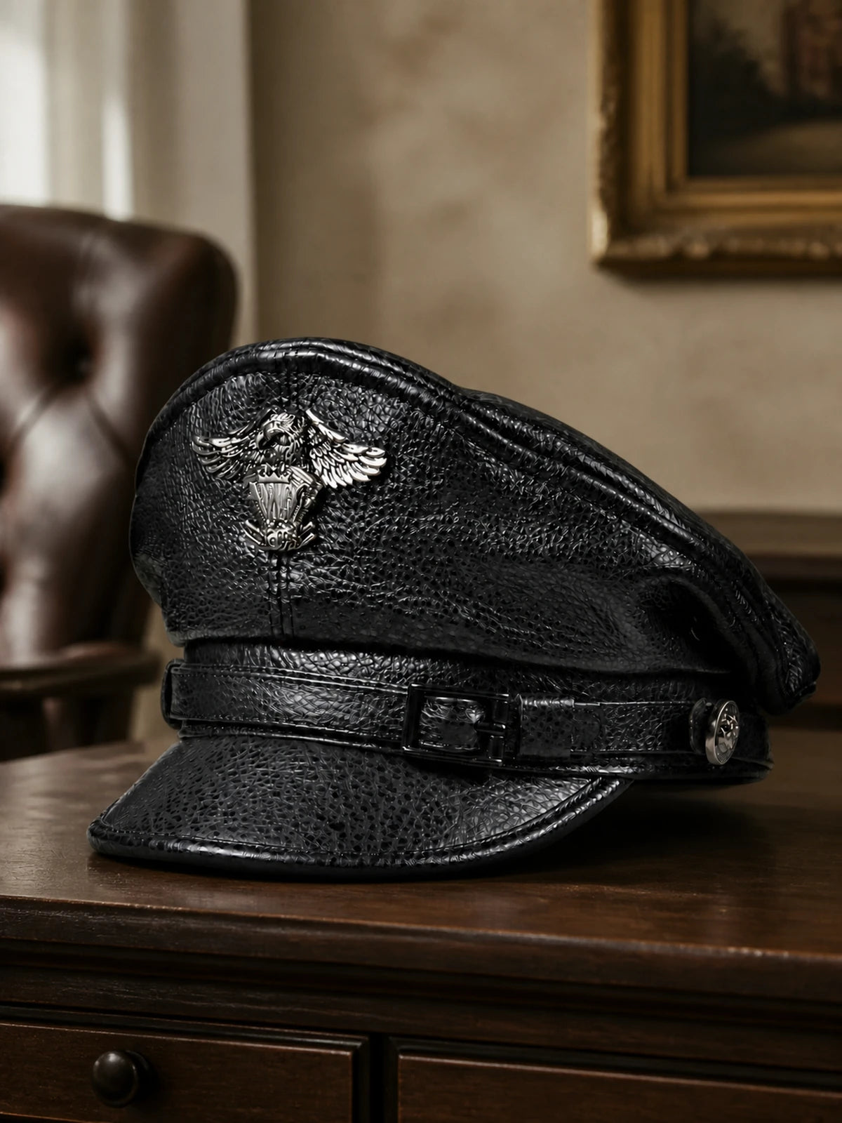 Men's genuine cowhide leather captain cap styled on a walnut console in a quiet study