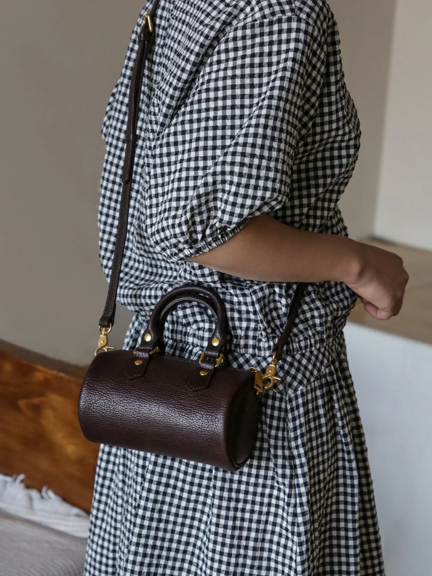 Coffee brown top-grain leather mini barrel bag worn crossbody