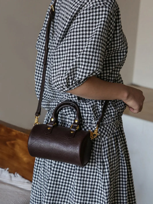 Coffee brown top-grain leather mini barrel bag worn crossbody