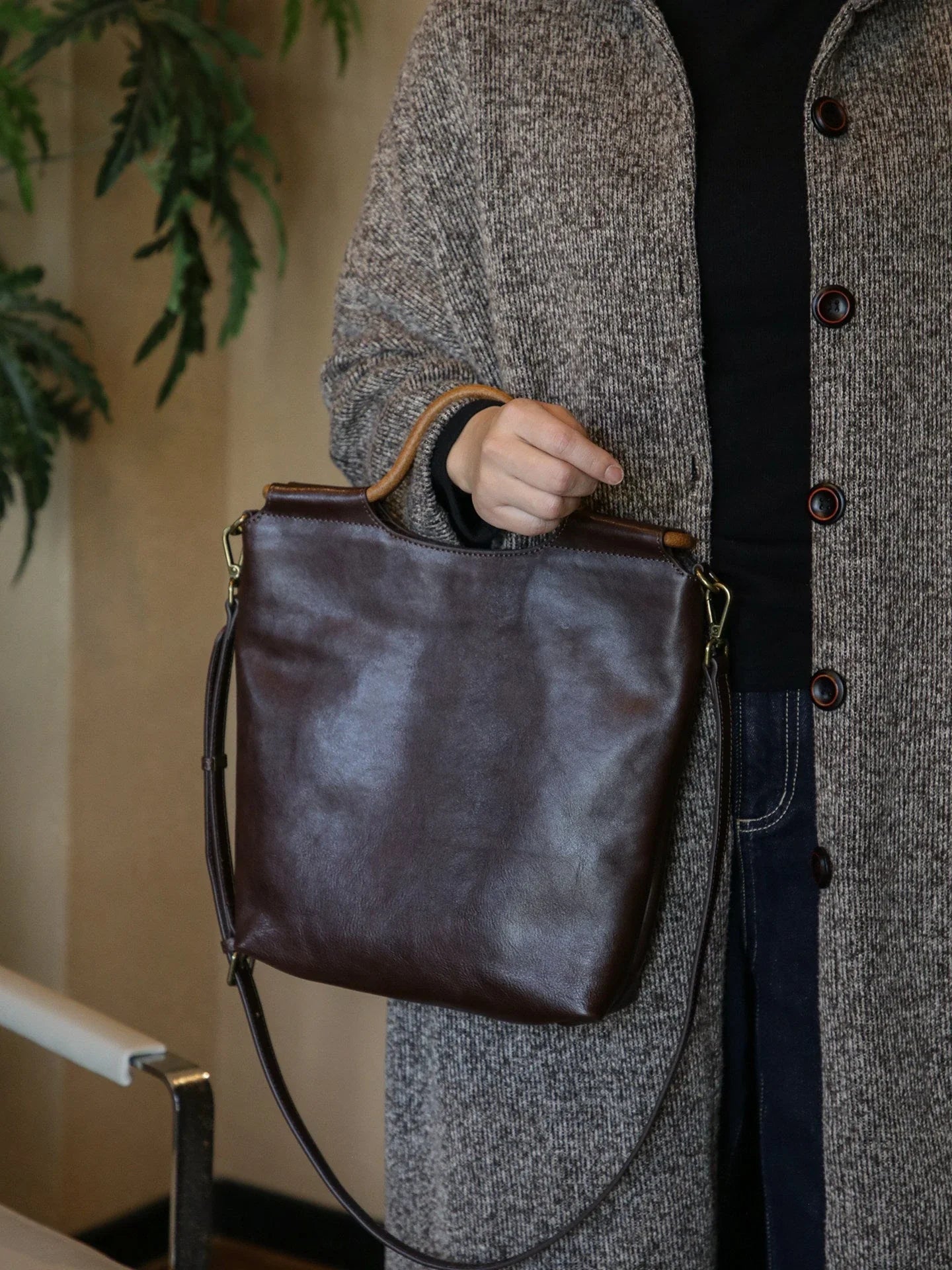 Ebony brown vegetable-tanned leather convertible tote bag carried by hand