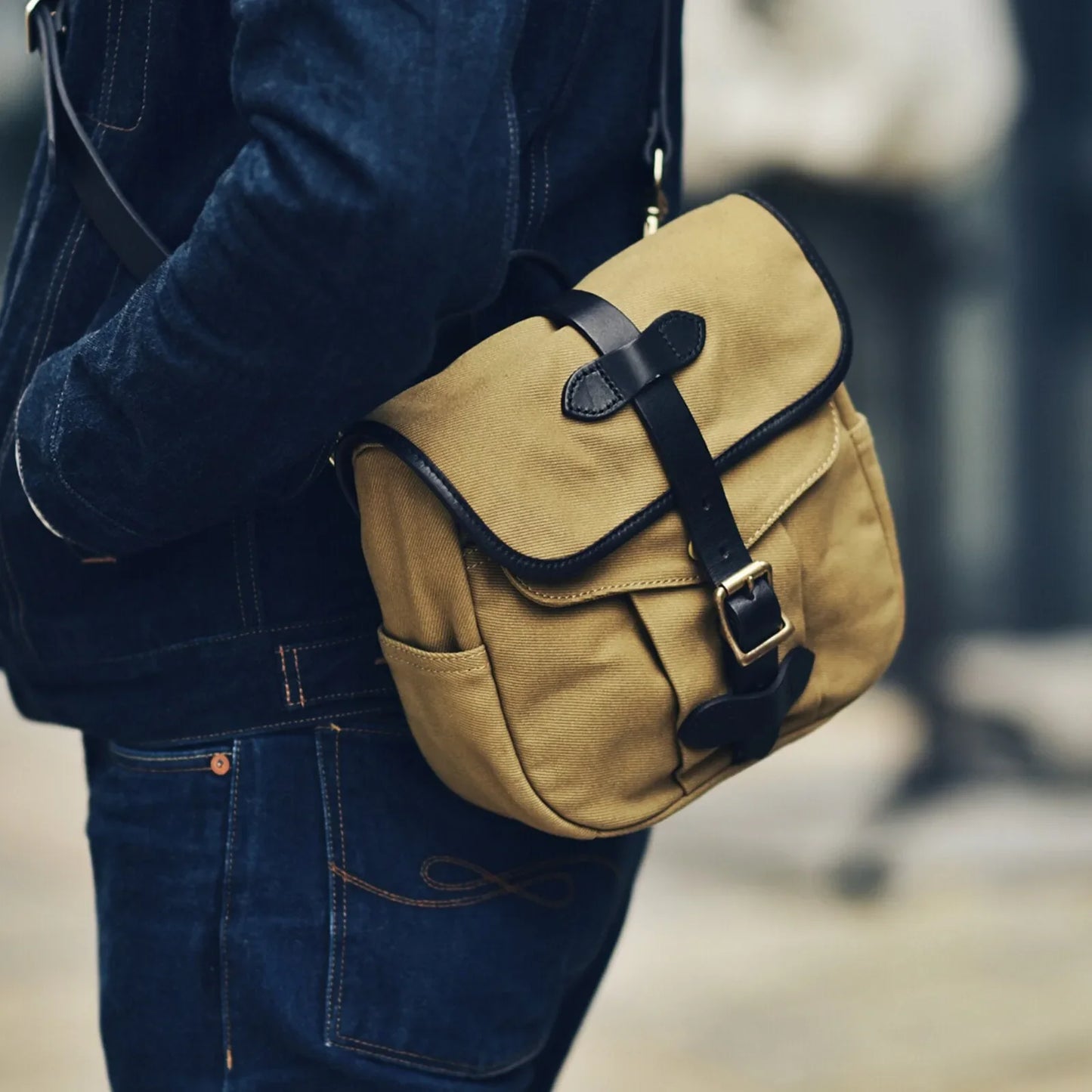 Waxed canvas and vegetable-tanned leather messenger bag worn crossbody in brown