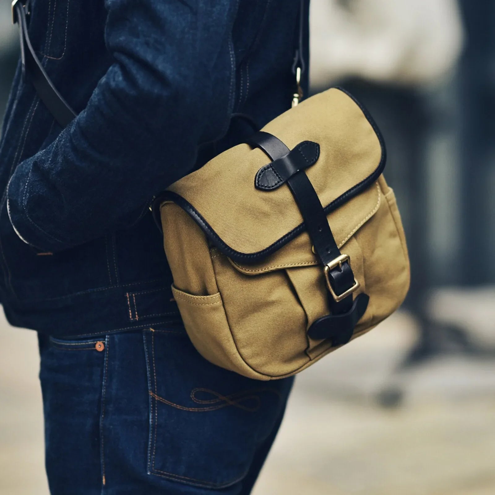 Waxed canvas and vegetable-tanned leather messenger bag worn crossbody in brown