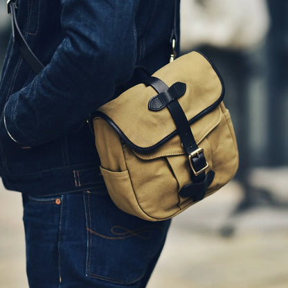 Waxed canvas and vegetable-tanned leather messenger bag worn crossbody in brown