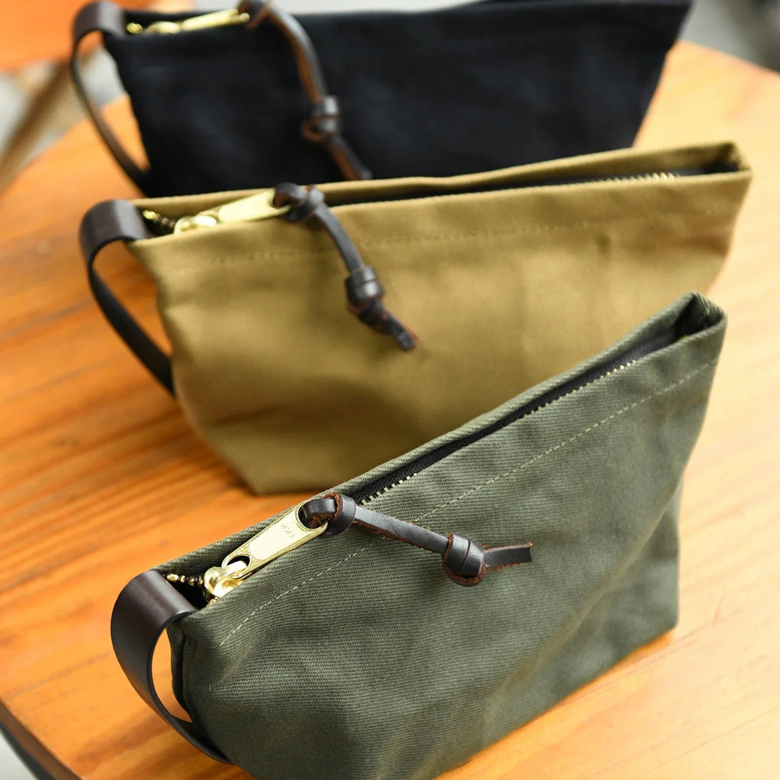Waxed canvas travel pouch in khaki, olive green and dark navy