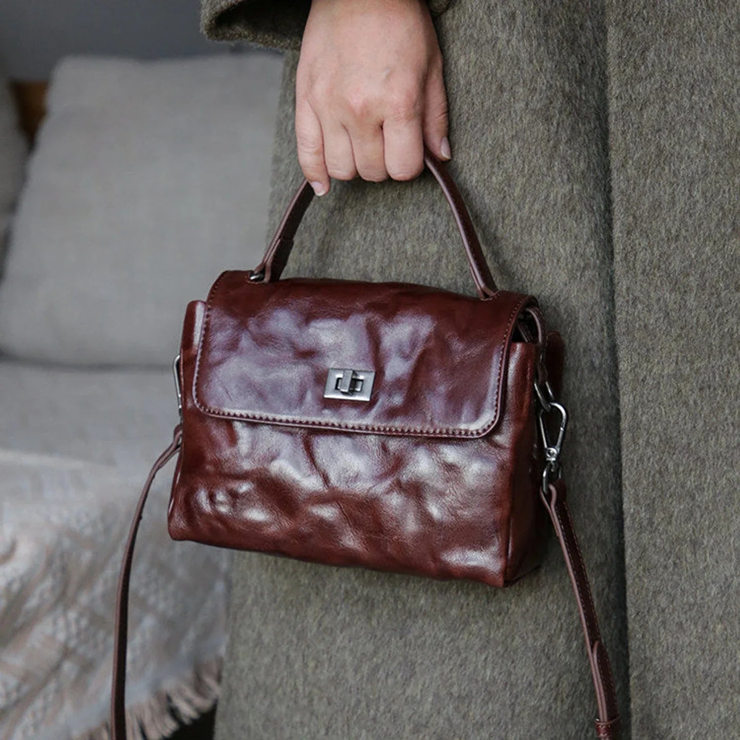 Women's chestnut brown top-grain leather satchel styled with a wool coat