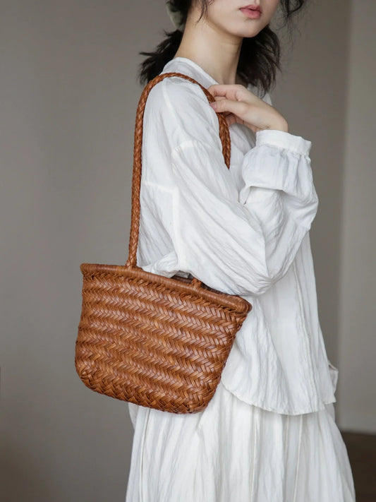 Vegetable-tanned woven leather shoulder bag in brown, styled with white clothing