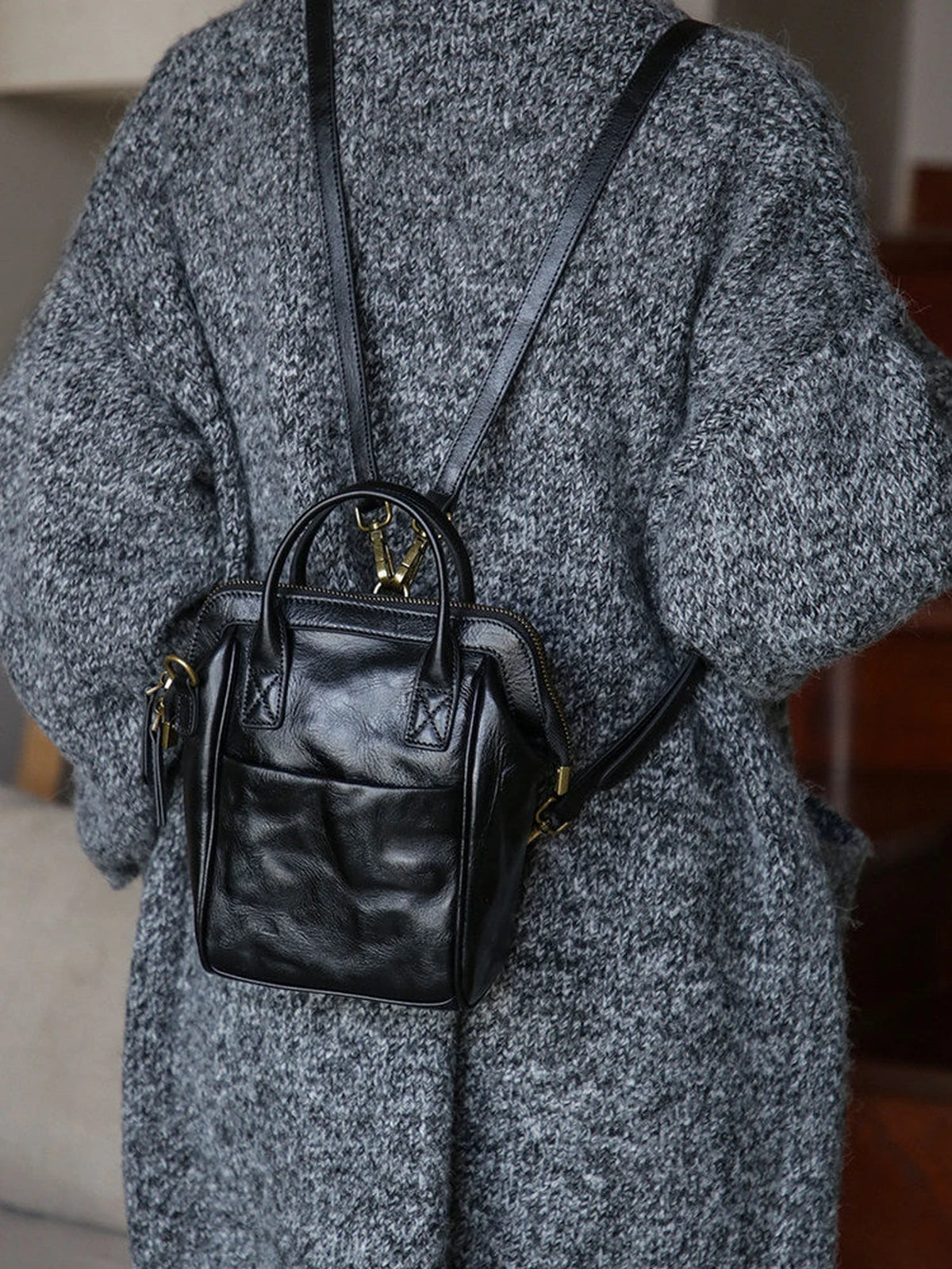 Black vegetable-tanned leather mini backpack worn on the back