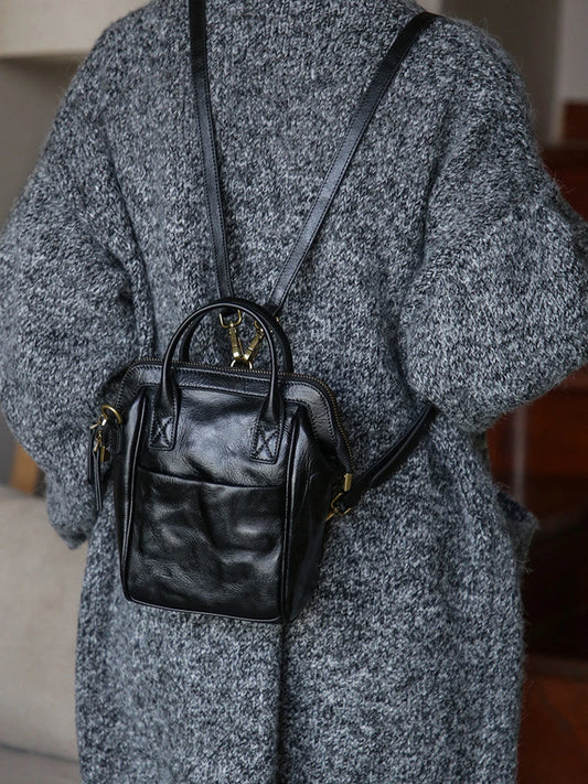 Black vegetable-tanned leather mini backpack worn on the back