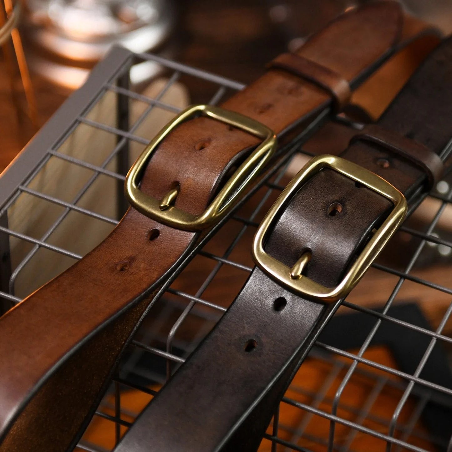 Brown and dark brown cowhide belts with aged brass-tone buckles