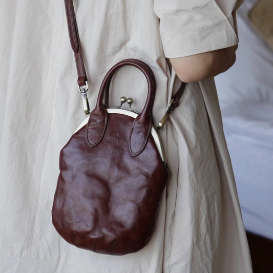 Brown kiss-lock leather crossbody phone bag shown from the back