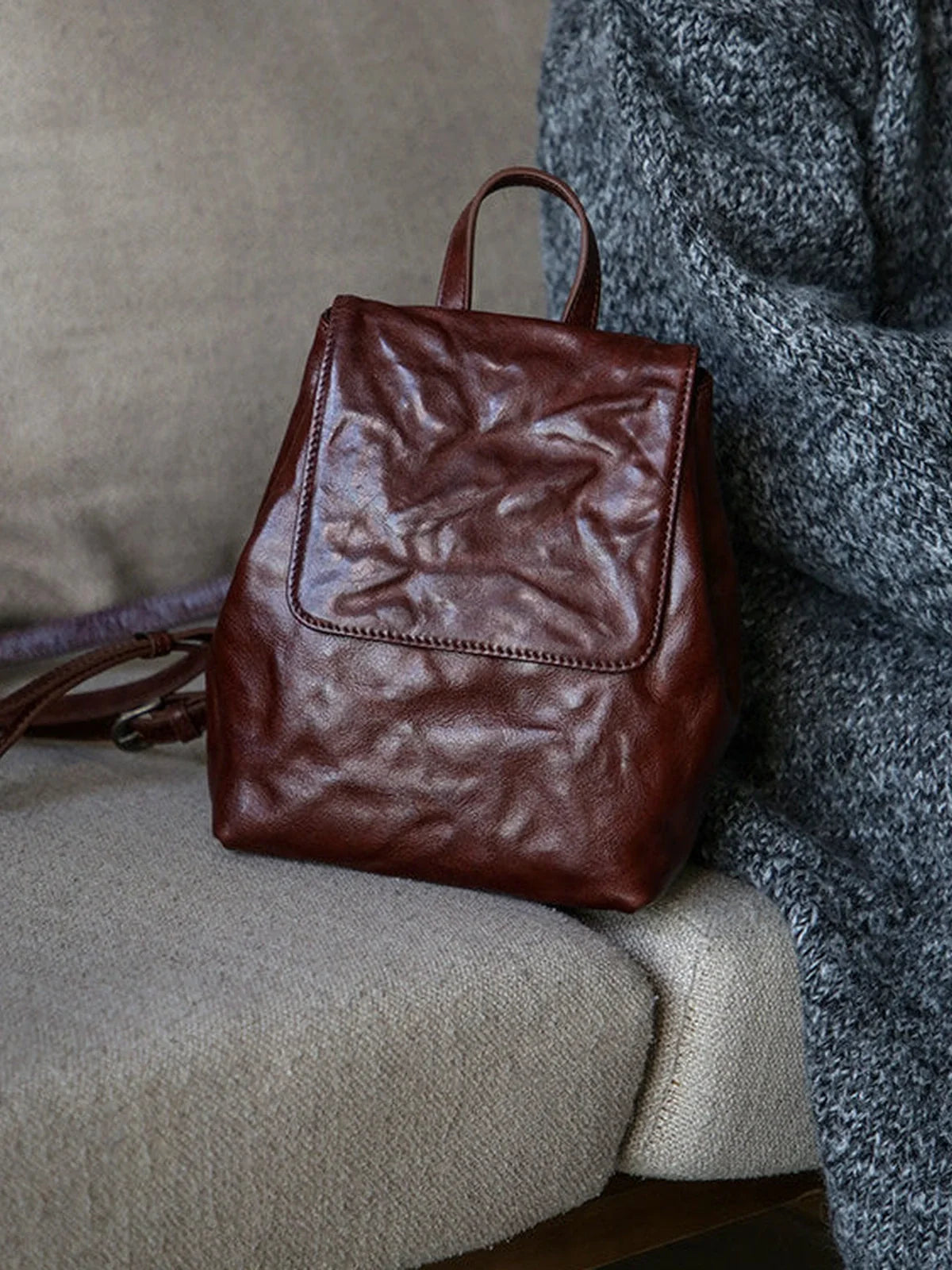 Coffee-brown cowhide mini backpack full view with top handle and flap