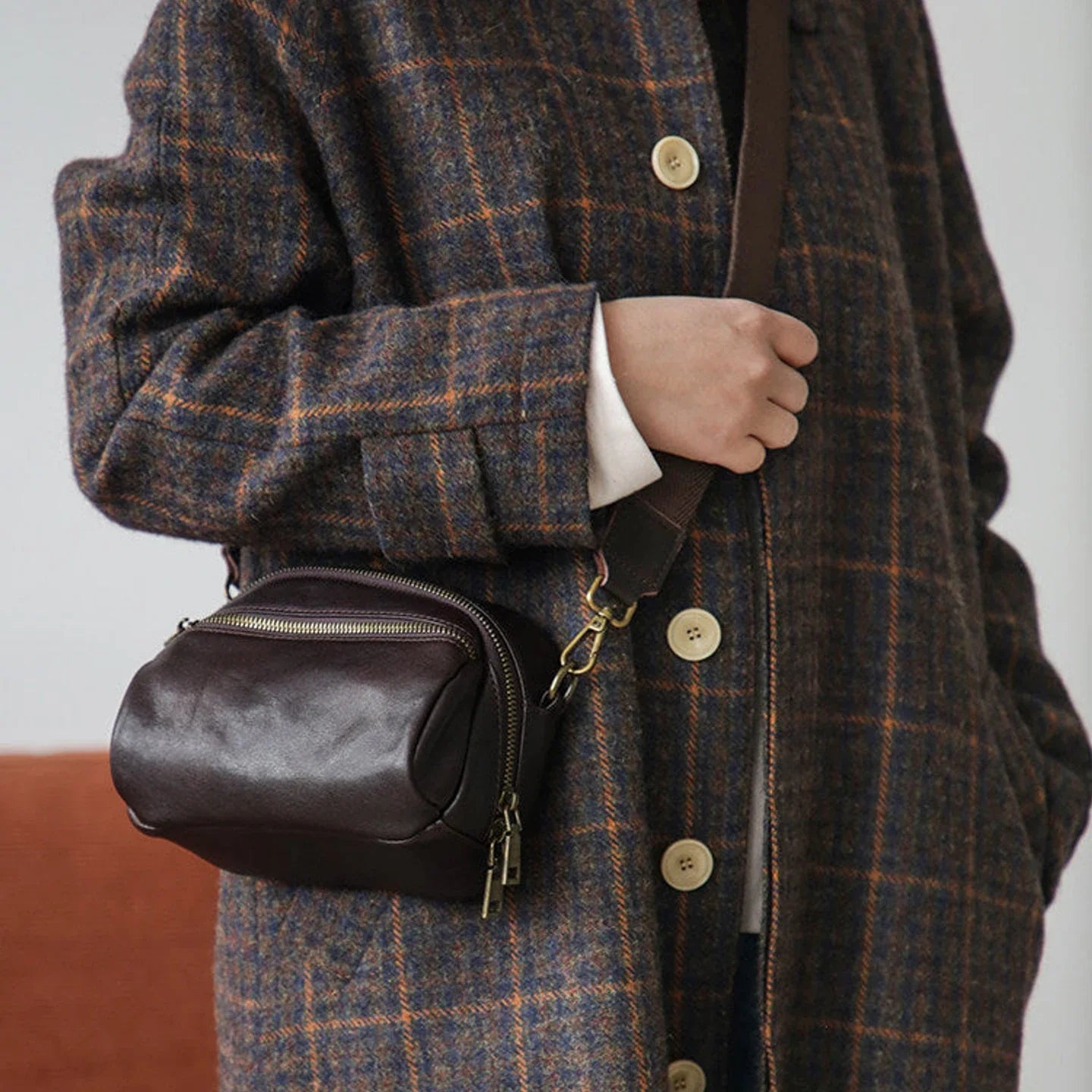 Women's coffee brown leather shoulder bag styled with a checked coat