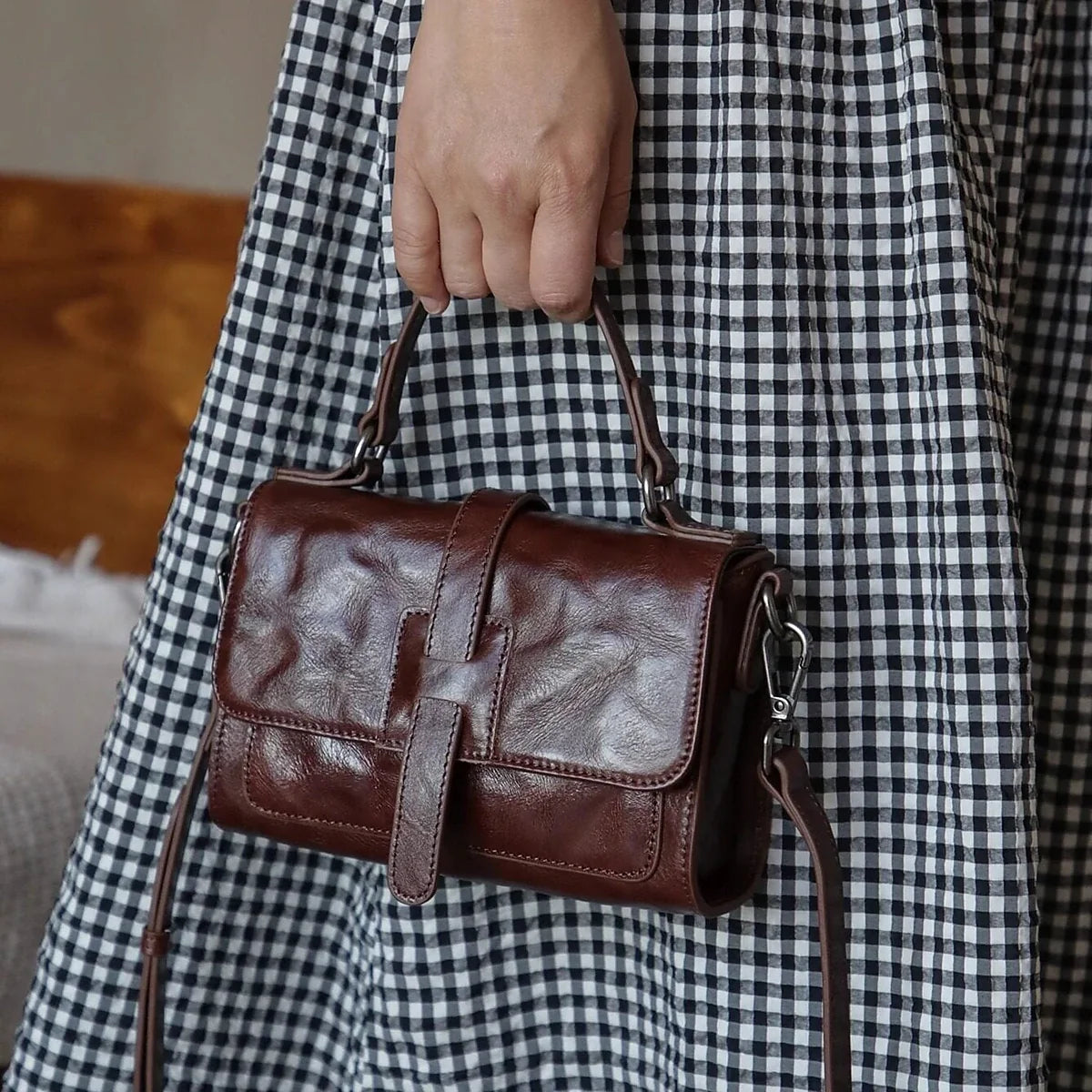 Coffee brown top-grain cowhide mini bag carried by the top handle