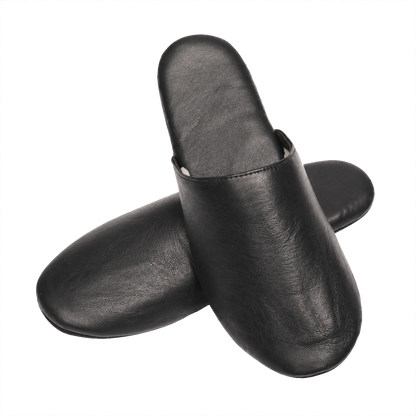 Black lambskin travel slippers crossed pair on a transparent background