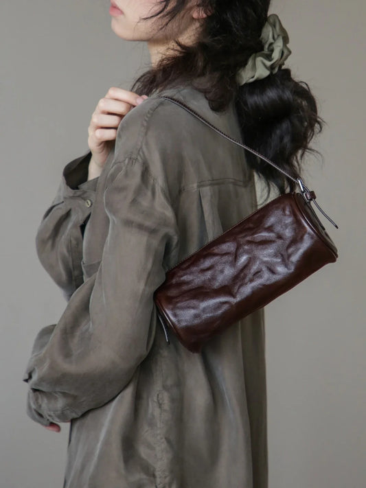 Espresso brown vegetable-tanned leather barrel bag close view