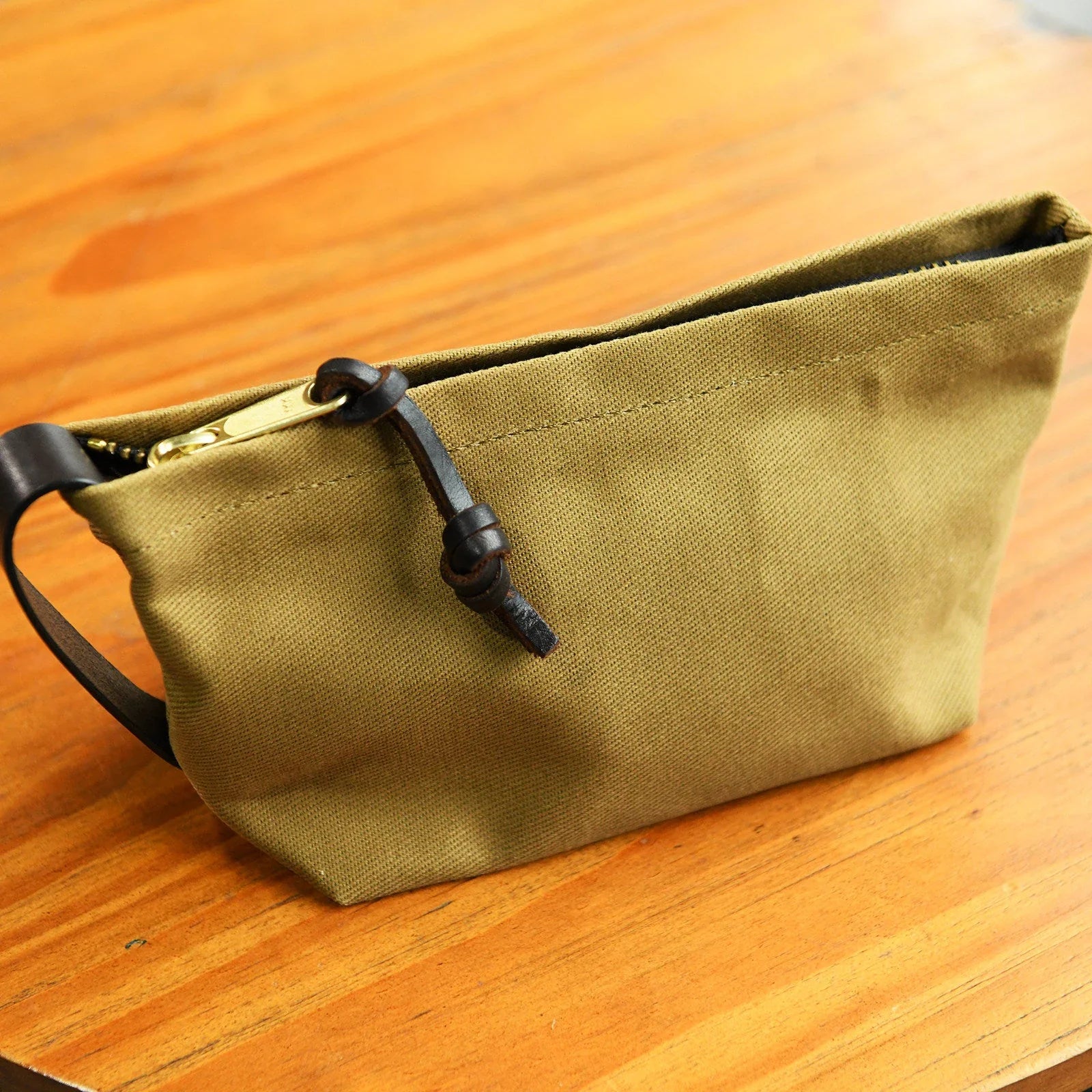 Khaki waxed canvas travel pouch with leather wrist loop