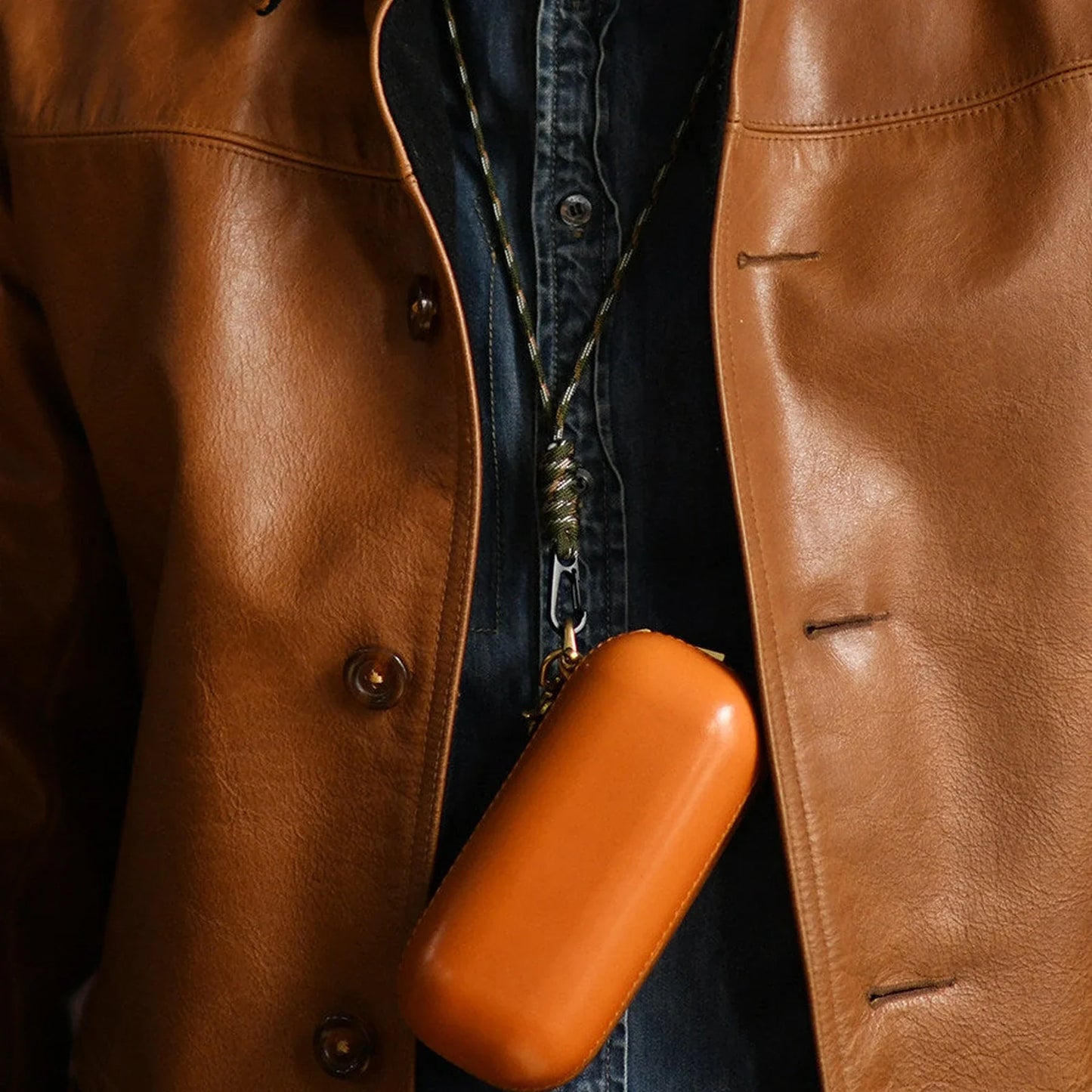 Tan vegetable-tanned leather eyeglass case worn with a clip