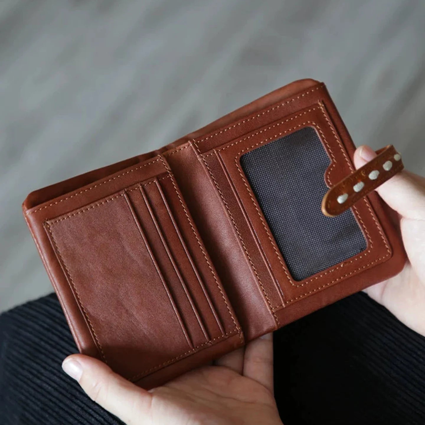 Brown leather wallet opened to show card slots and identification window