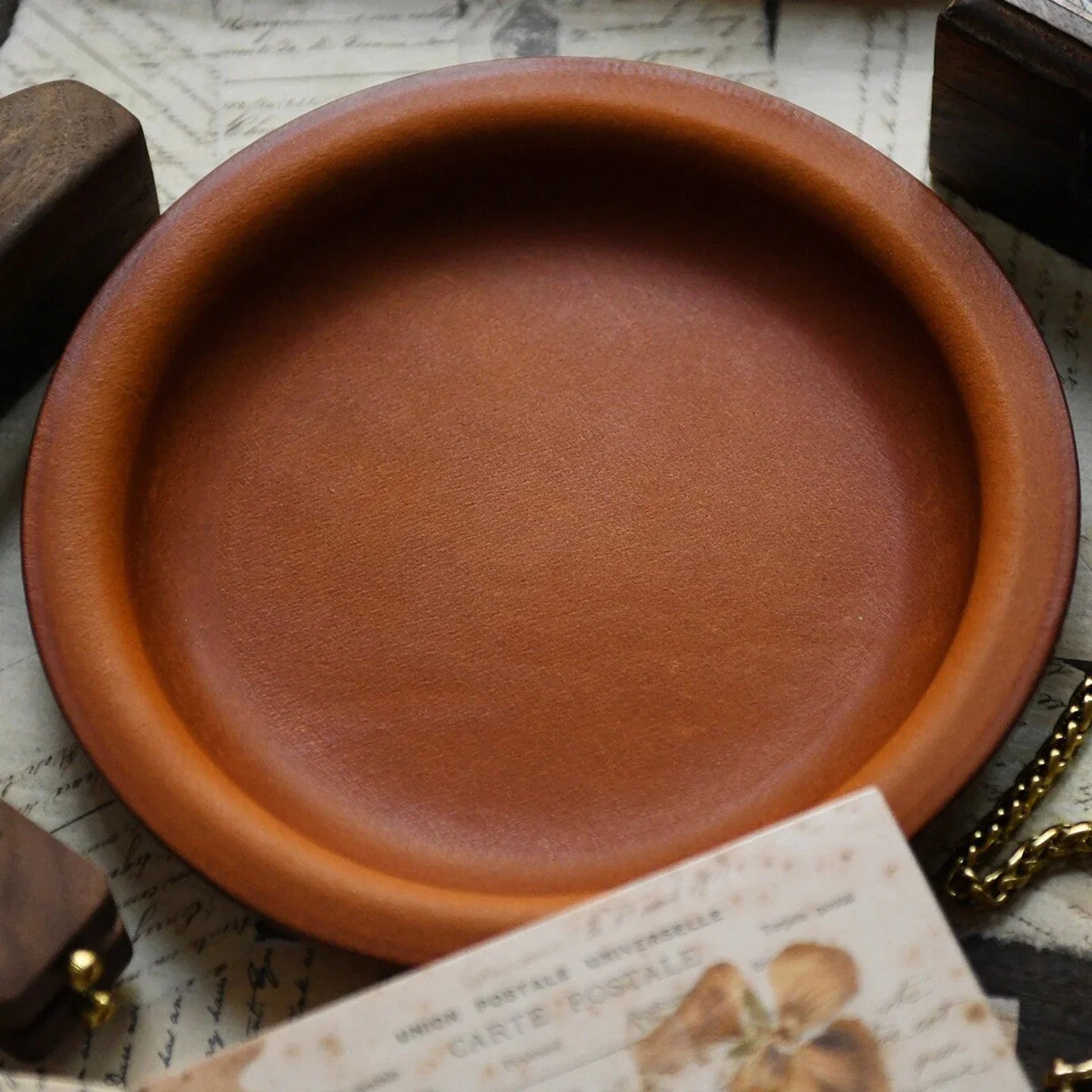 Round vegetable-tanned cowhide valet tray in a vintage desk setting