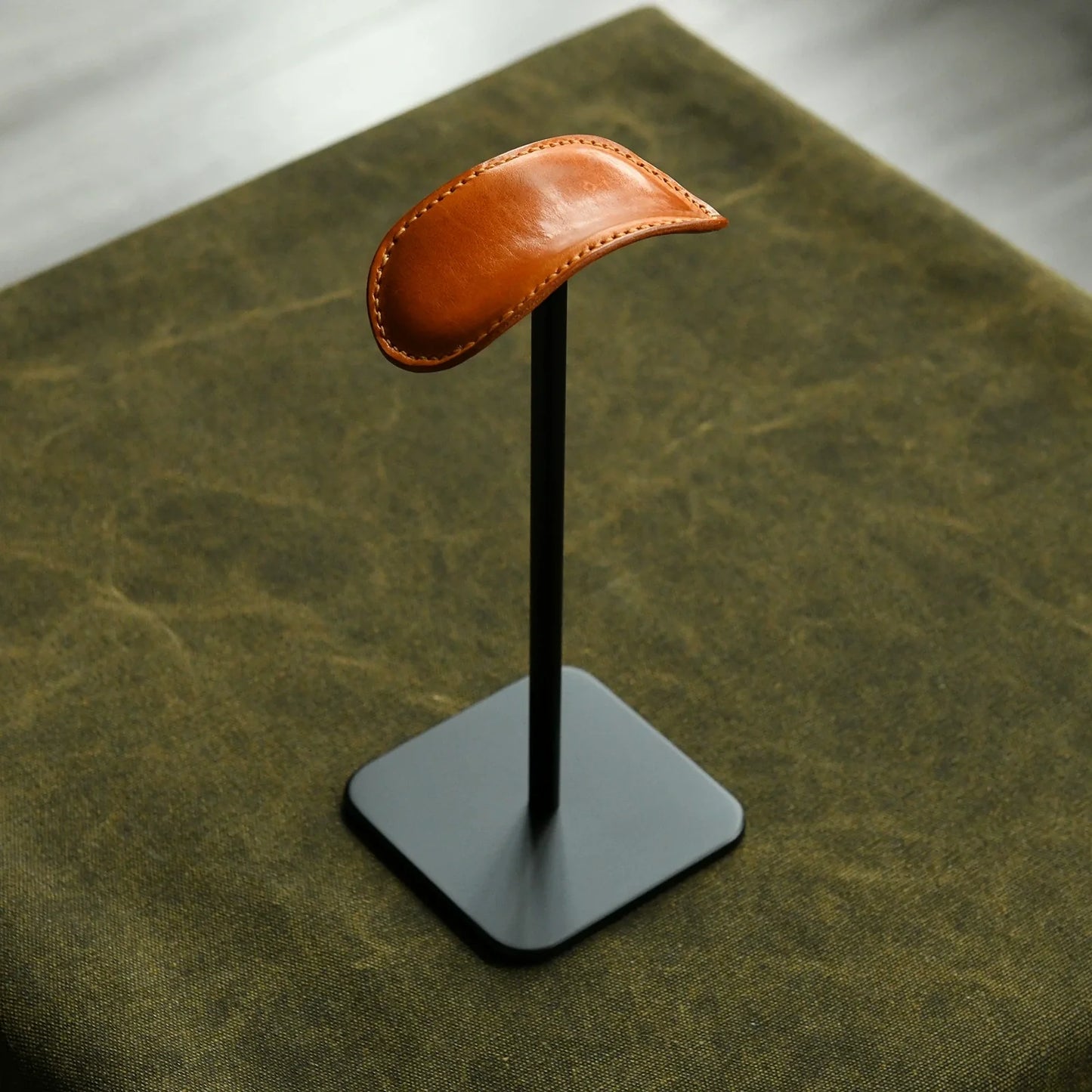 Tan cowhide and black metal headphone stand full view