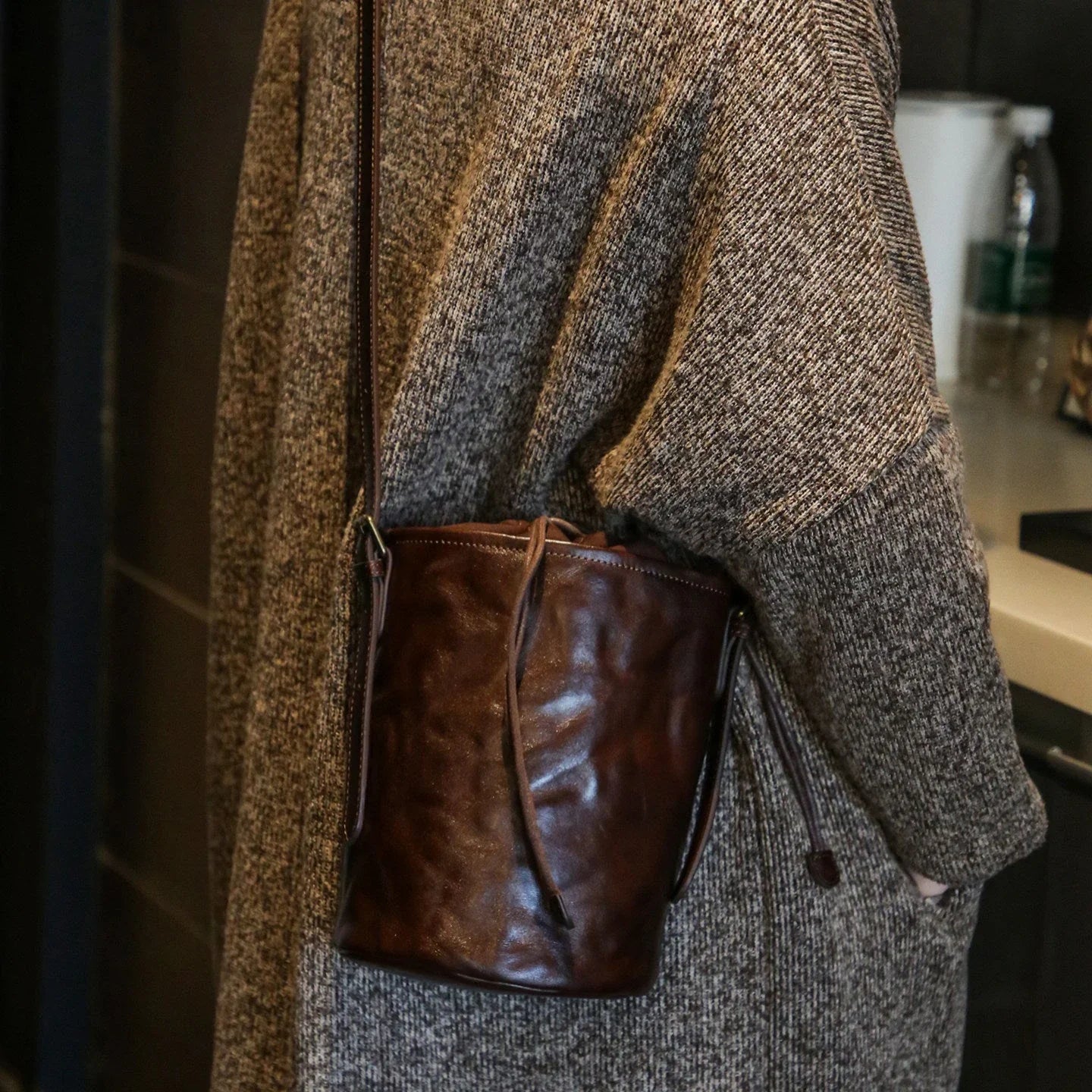 Ebony brown top-grain leather bucket bag styled crossbody