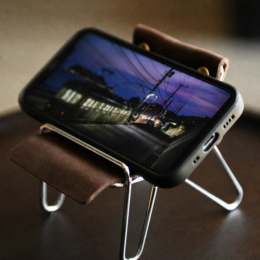 Leather desktop phone stand holding a phone in landscape orientation