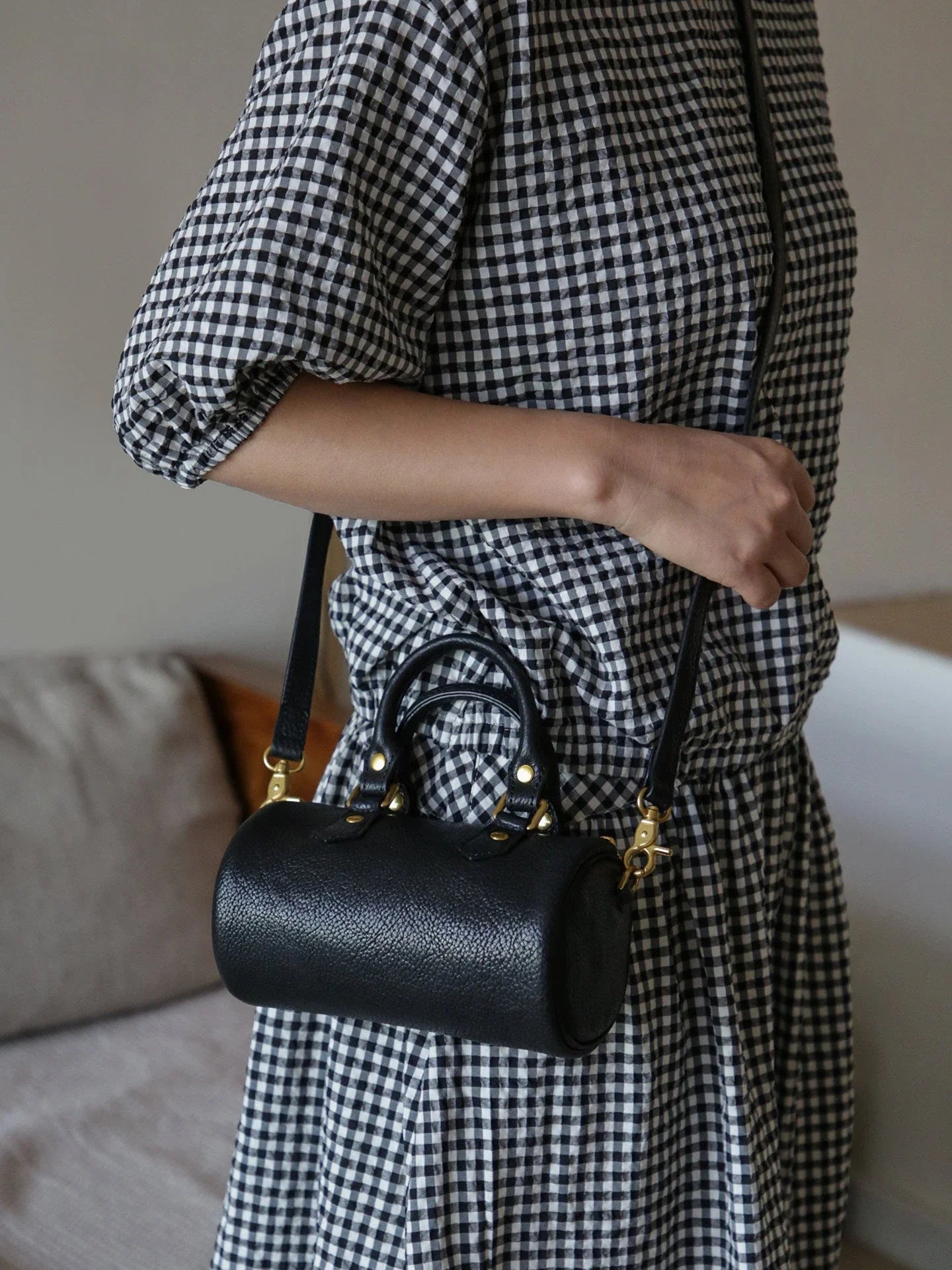 Black vegetable-tanned leather mini barrel bag worn crossbody