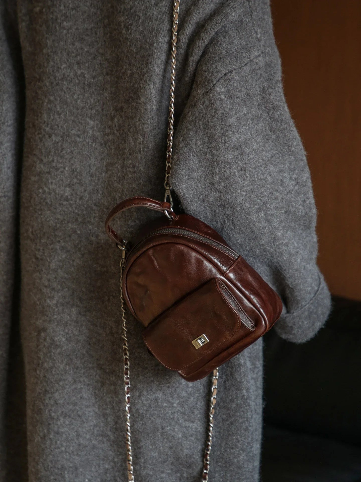 Side view of an ebony brown vegetable-tanned leather mini backpack