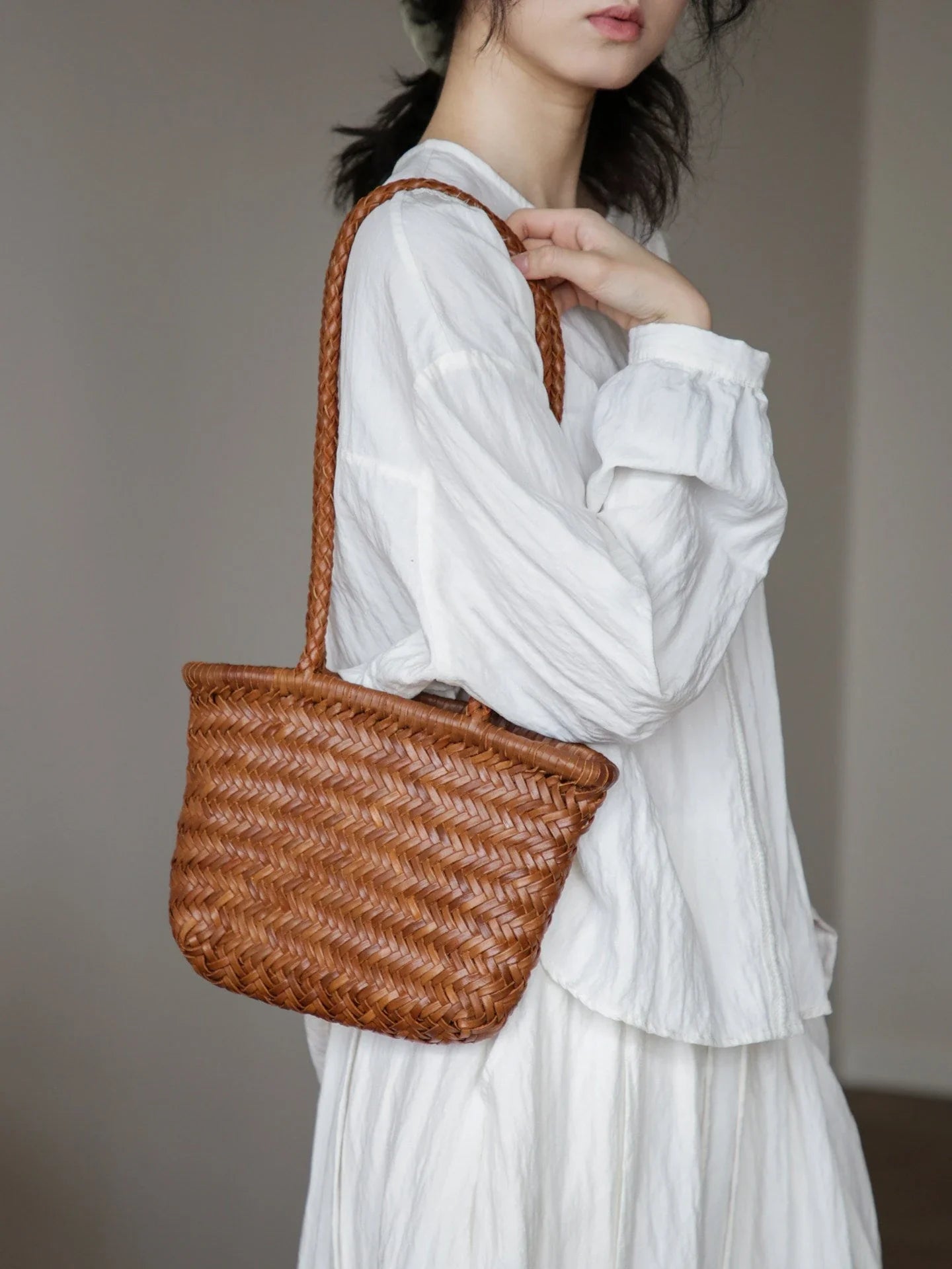 Brown woven leather shoulder bag shown from the side