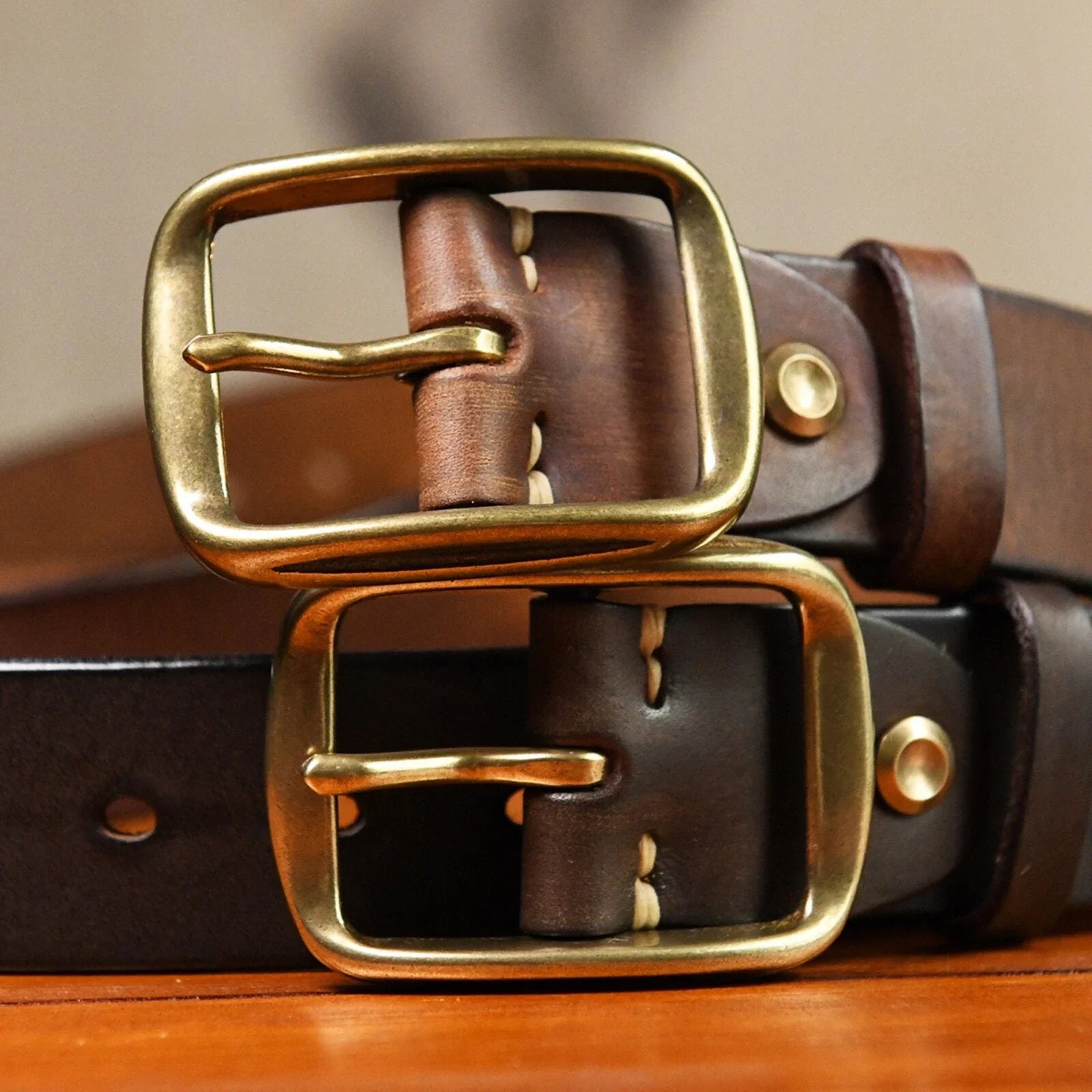 Close detail of aged brass-tone buckles on brown cowhide belts
