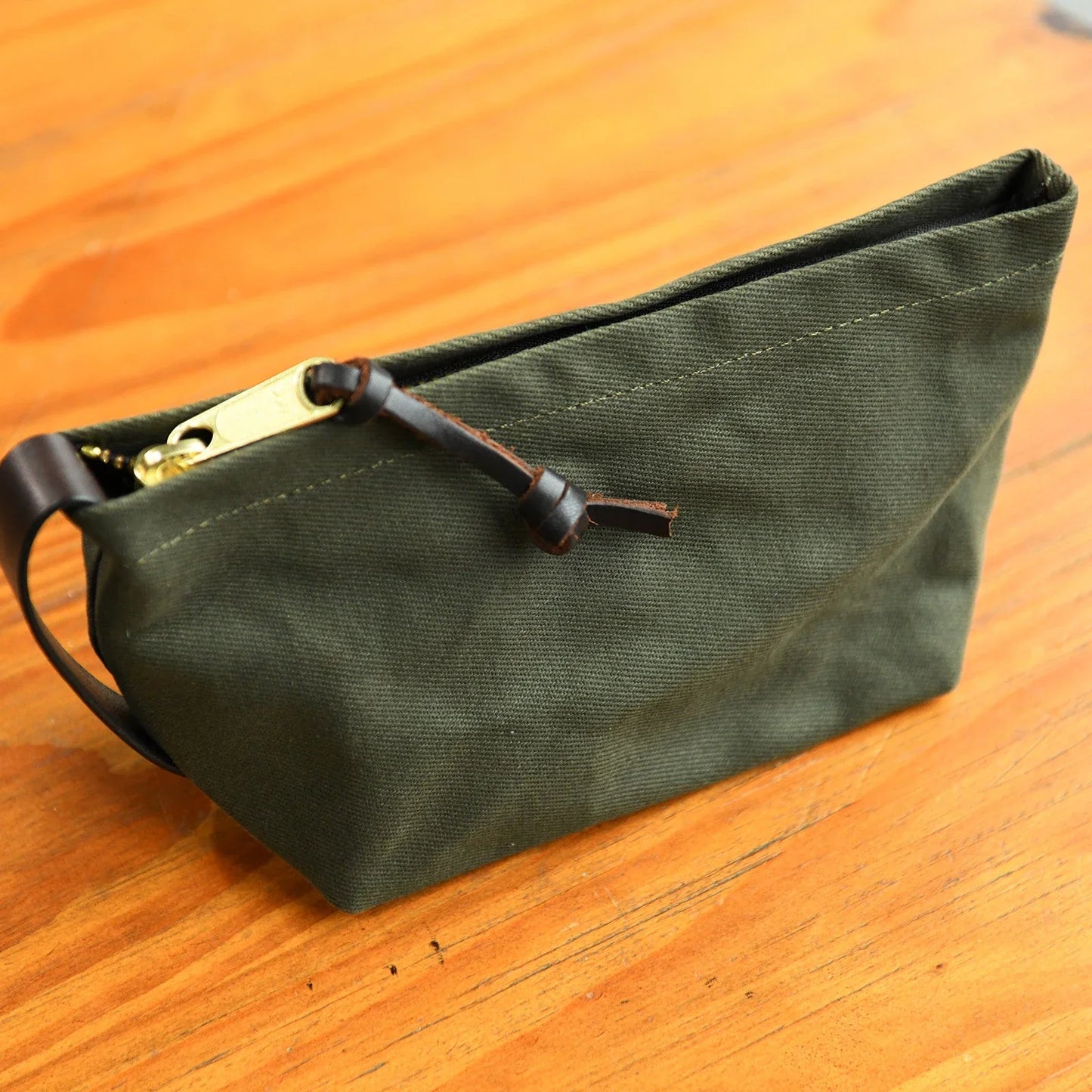 Olive green waxed canvas travel pouch with leather trim