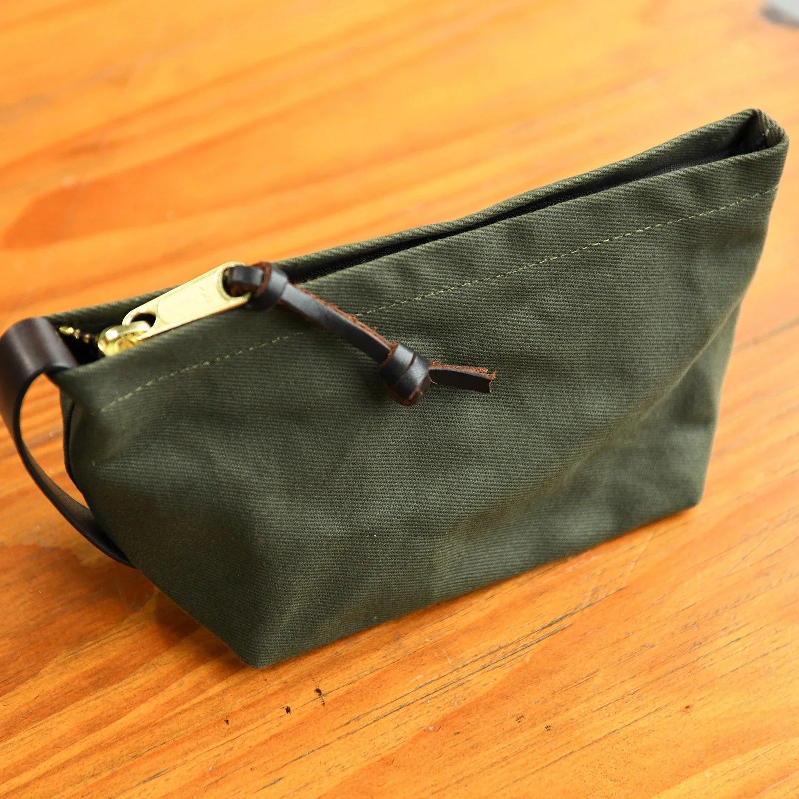 Olive green waxed canvas travel pouch with leather trim