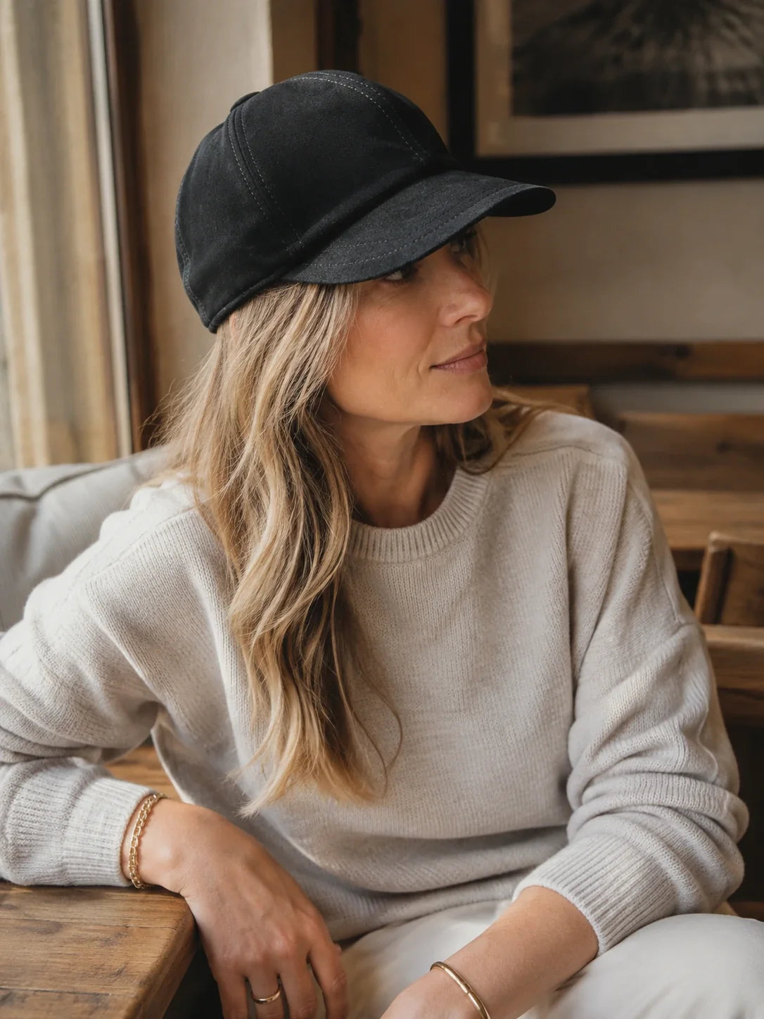 Side profile of a woman wearing a black suede lambskin beret cap