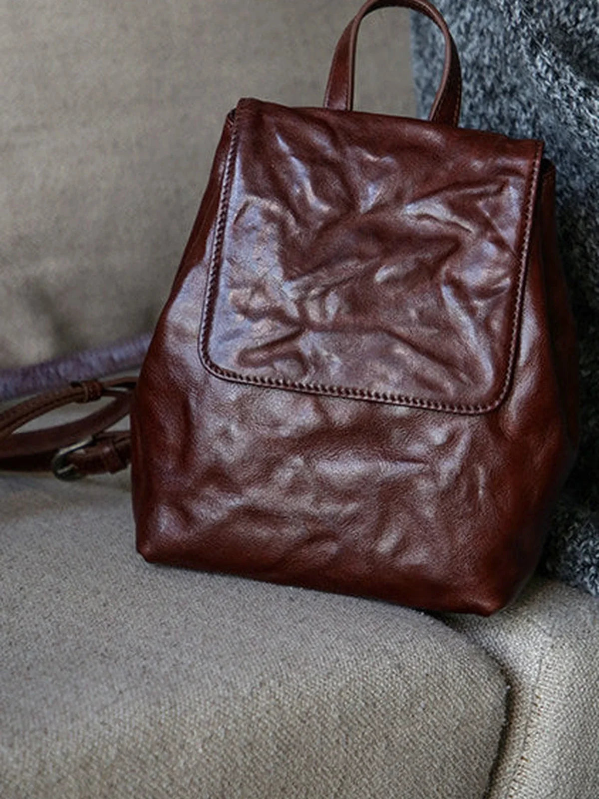 Close detail of the coffee-brown cowhide grain and front flap